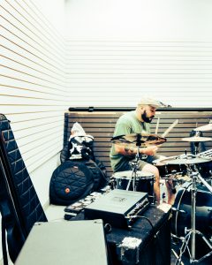 drumer for the band Last Remorse surrounded by gear and a drum kit