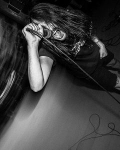 man singing during an Axe Collector concert at the Mystery Shop