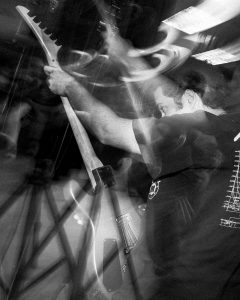 Black and white action shot of guitar player from Level