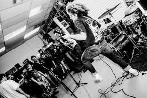 black and white photo of a man with a guitar from the band Flak