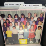 A vinyl record cover in a record flip bin. The record is priced at $10 and its cover displays an elementary school class with a sign that says "Tierra Vista Elementary Presents" There are two tab dividers visible in the bin that read "805 Artists - LP's New" and "Yay! Records."